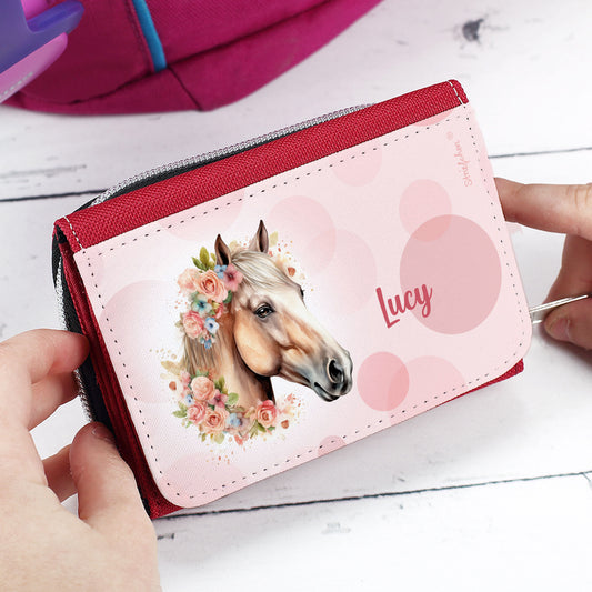 Rote Mädchen-Geldbörse mit Pferd und Name „Lucy“ – Nahaufnahme auf Tisch