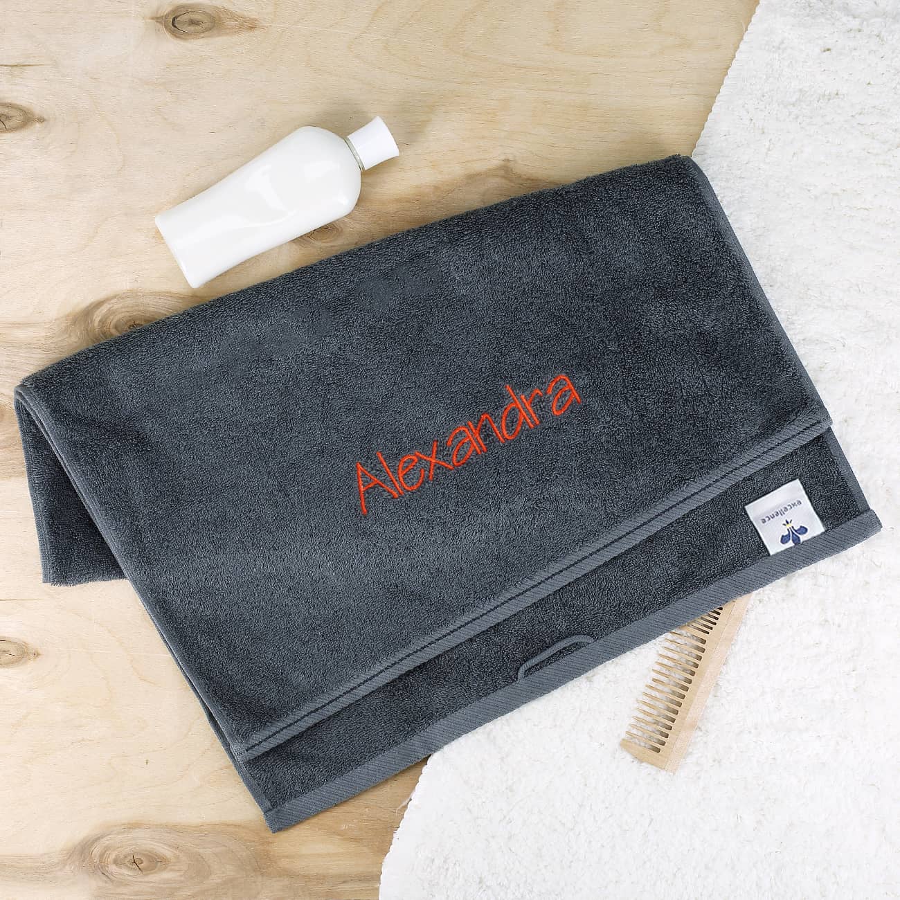 Handtuch in schiefergrau mit Name bestickt in orange