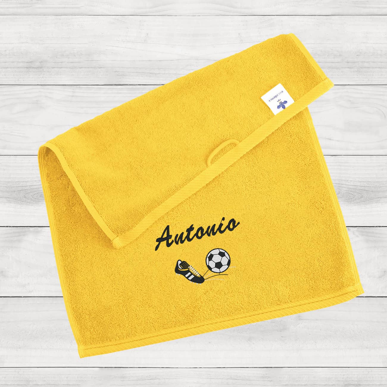 Gelbes Gästehandtuch mit Name und Fußball bestickt