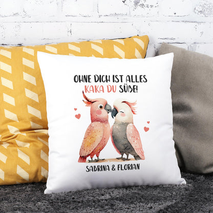 Personalisiertes Kakadu-Kissen mit romantischem Spruch und zwei Namen, dekoriert auf Sofa vor Backsteinwand