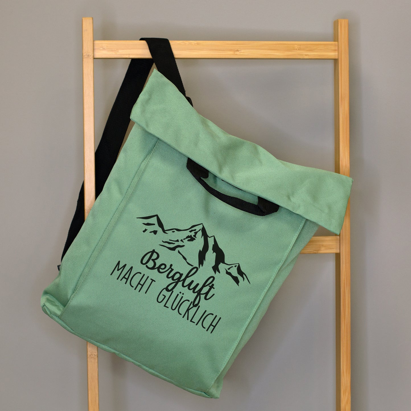 Jadegrüner 2-in-1 Rucksack mit Bergmotiv und Wunschtext „Bergluft macht glücklich“