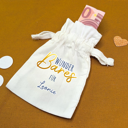 Stoffbeutel mit Aufdruck „WunderBares für Leonie“, daneben Dekoelemente und 10-Euro-Schein