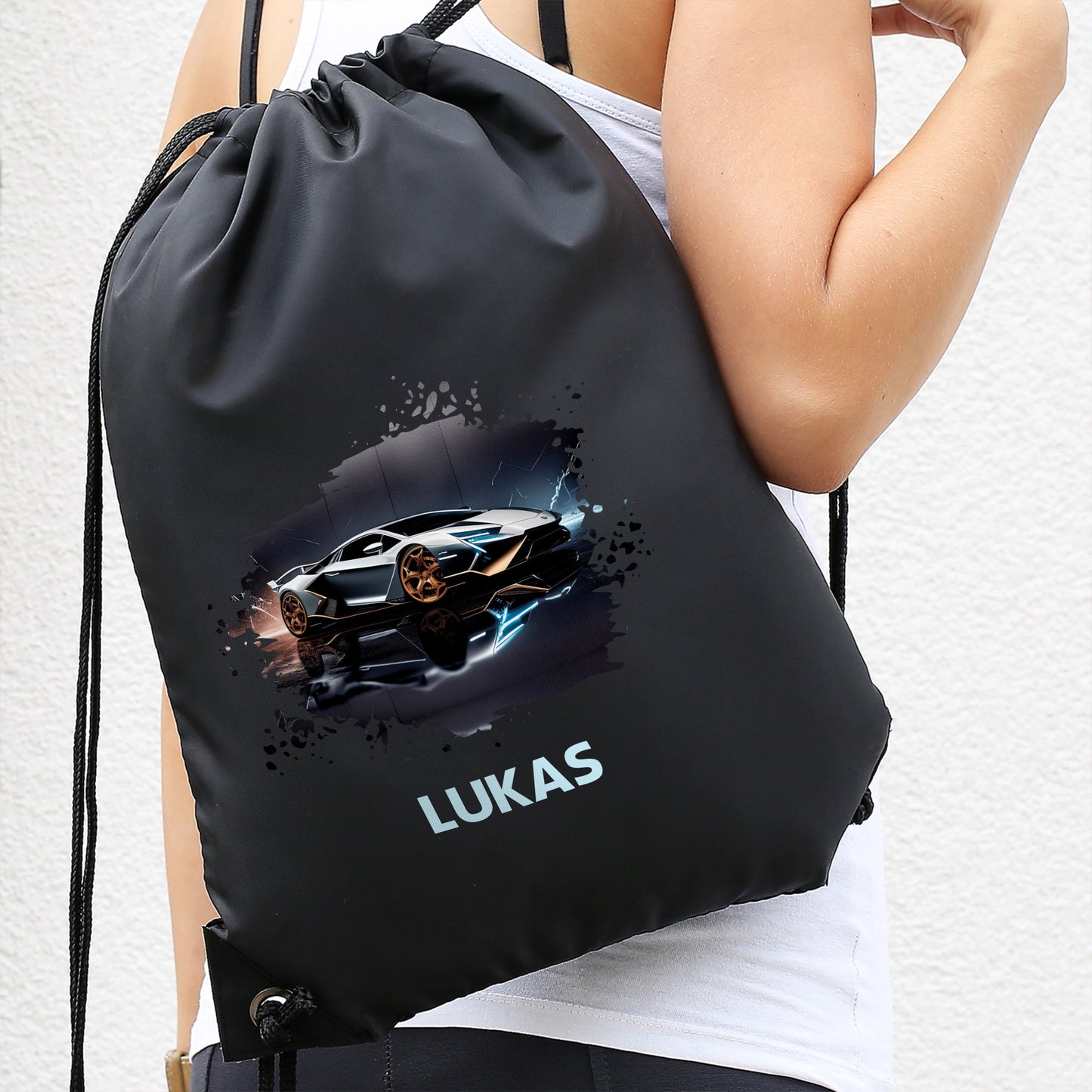 Schwarzer Turnbeutel mit Sportwagen-Design und Name „Lukas“, getragen auf dem Rücken