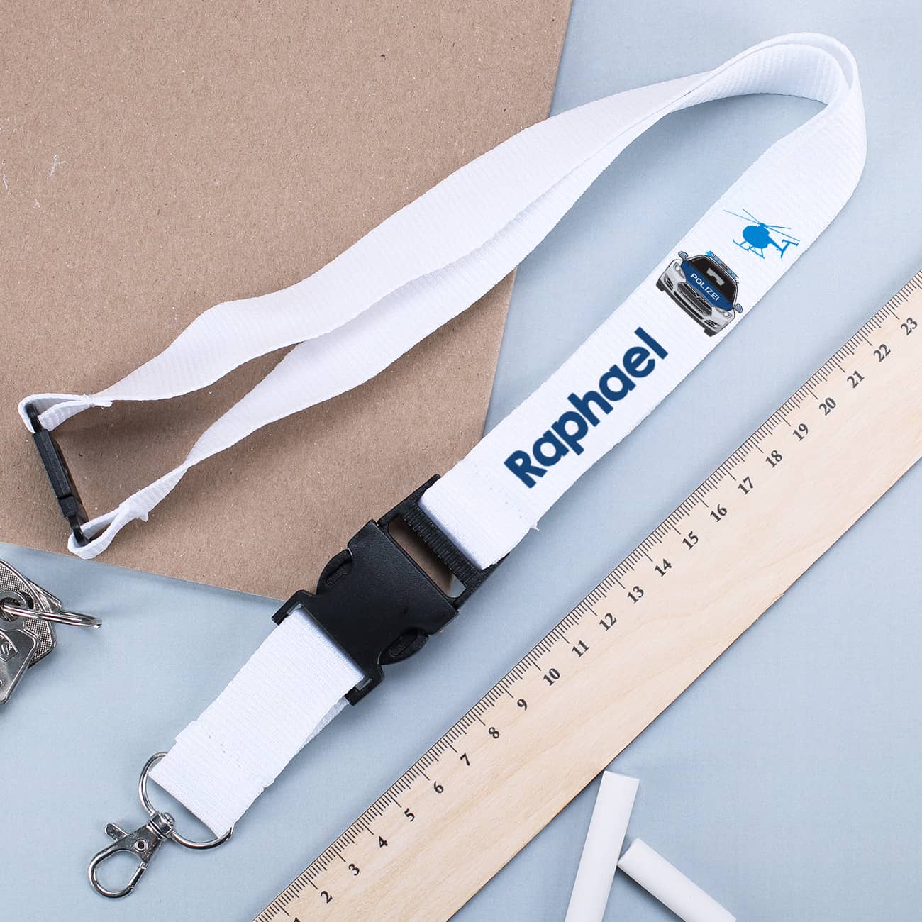 Weißes Schlüsselband mit Polizeiauto und Name bedruckt