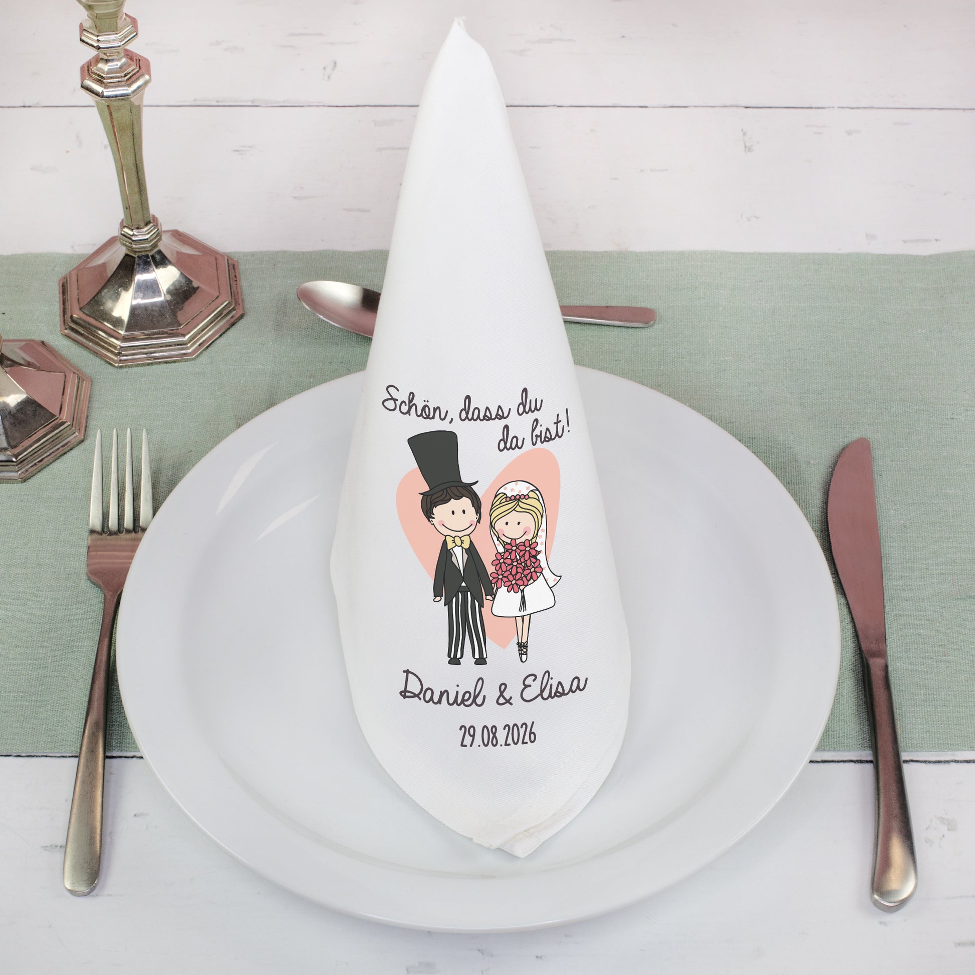 Stoffserviette Hochzeit personalisiert gefaltet auf Teller mit Besteck und Brautpaar Design