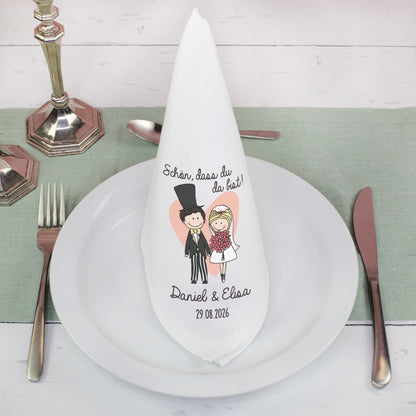 Stoffserviette Hochzeit personalisiert gefaltet auf Teller mit Besteck und Brautpaar Design