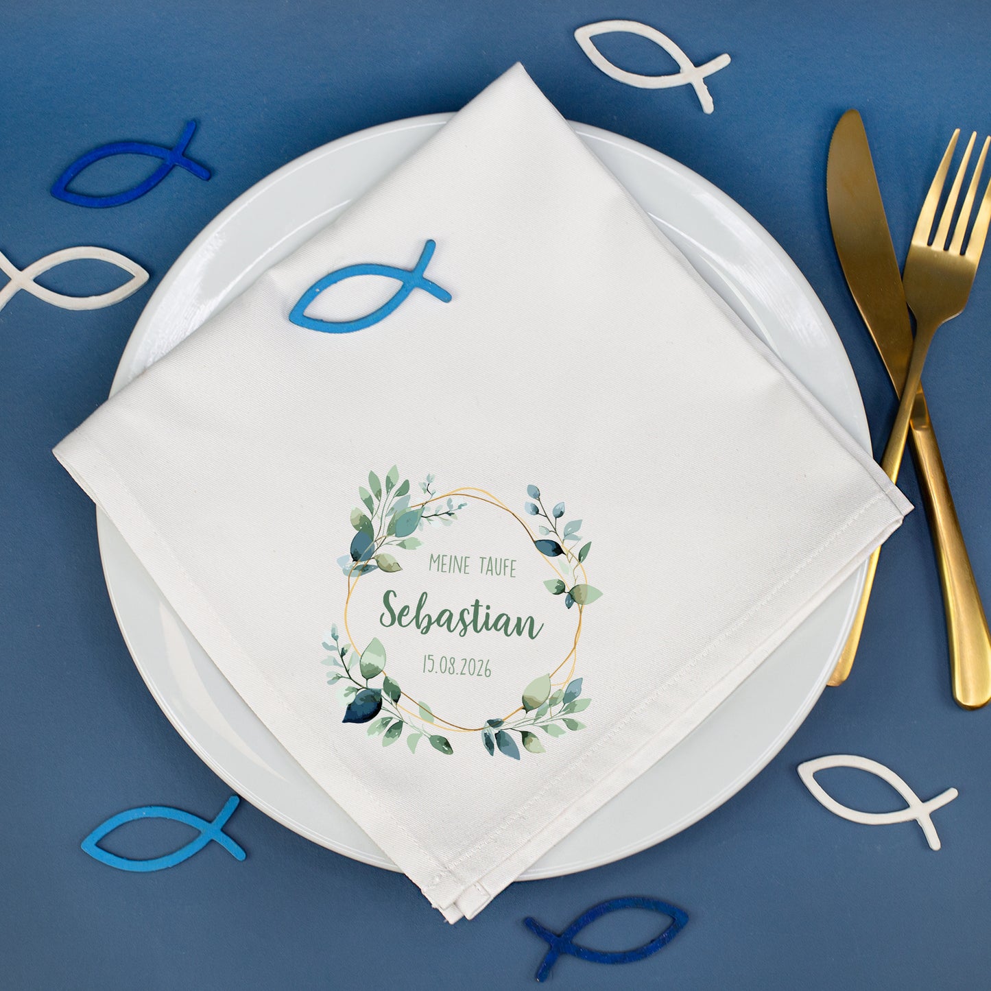 Personalisierte Stoffserviette Taufe mit Eukalyptusmotiv und Name Sebastian auf gedecktem Tisch mit Fischsymbolen