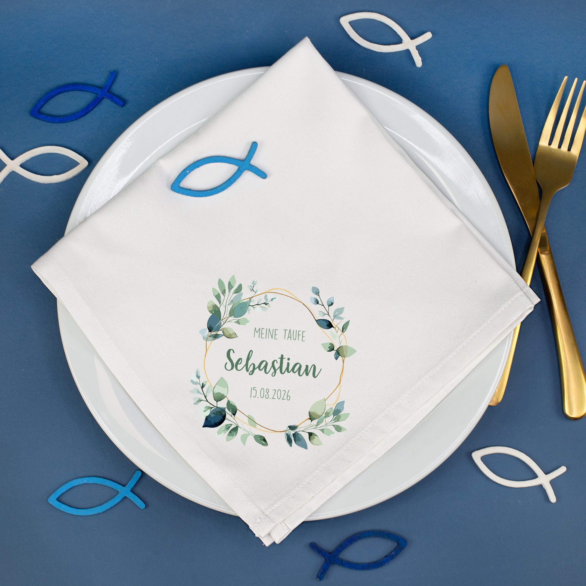 Personalisierte Stoffserviette Taufe mit Eukalyptusmotiv und Name Sebastian auf gedecktem Tisch mit Fischsymbolen