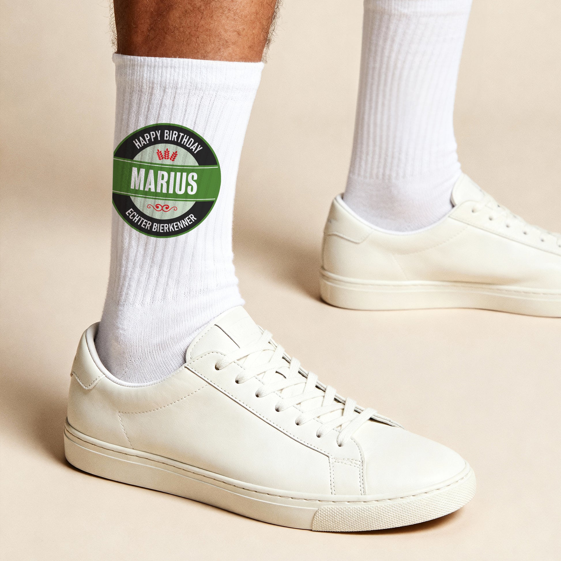 Weiße Sportsocken mit personalisiertem Bierlogo und Text „Happy Birthday Marius – Echter Bierkenner“ – getragen mit weißen Sneakern.
