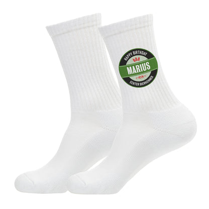 Freigestellte Aufnahme eines Sockenpaares mit personalisiertem Bierlogo und Name „Marius“ – Studioaufnahme vor weißem Hintergrund.