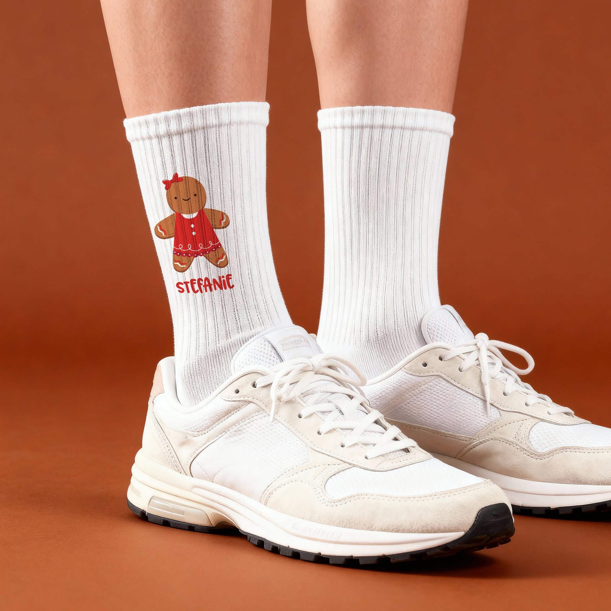 Weißer Tennissocken mit rotem Lebkuchenfrau-Motiv und personalisiertem Namen, getragen mit Sportschuhen.