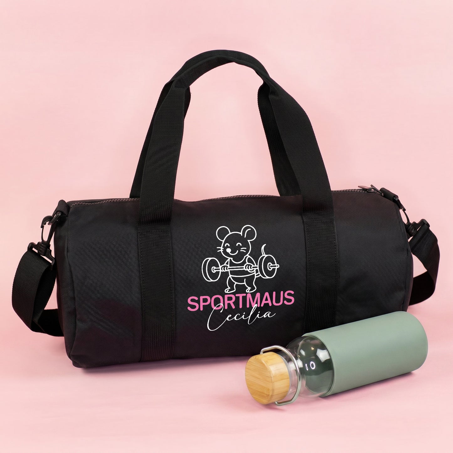 Schwarze Sporttasche mit Sportmaus Motiv, personalisiert mit Name Cecilia, neben Trinkflasche auf rosa Hintergrund