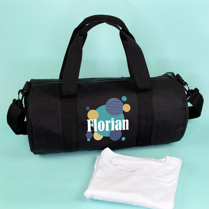 Schwarze Sporttasche mit modernem Kreis-Motiv und personalisiertem Namen Florian neben weißem Shirt
