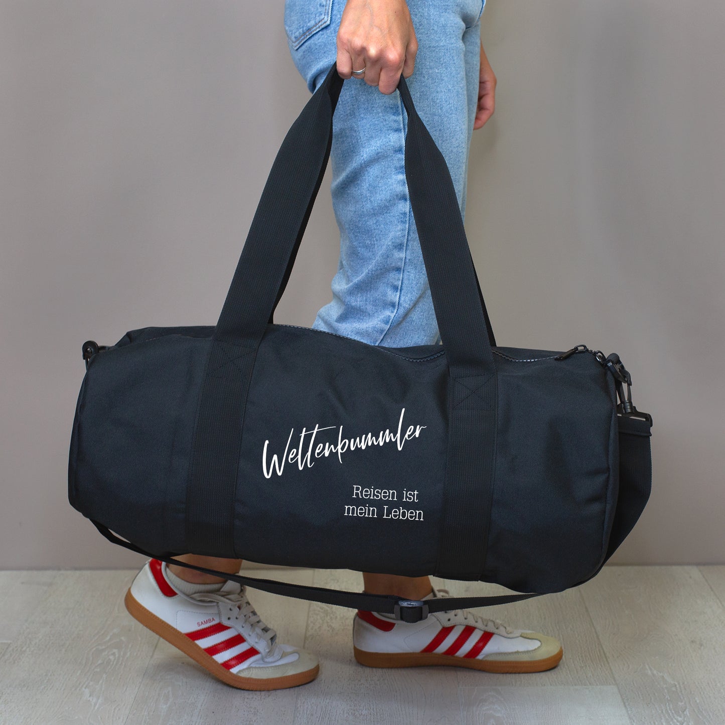 Schwarze XL Sporttasche mit Wunschtext, getragen als Trainingstasche.
