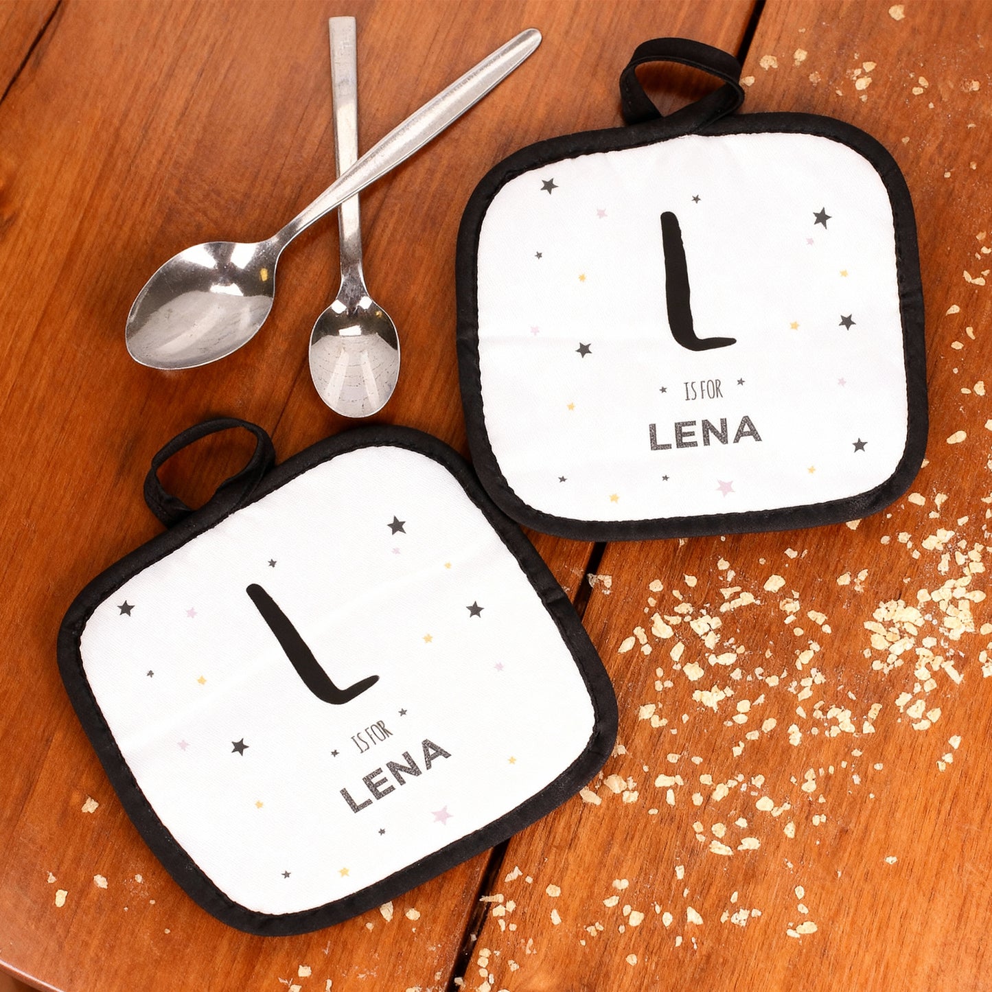 Topflappen-Set mit Initial „L is for Lena“ dekoriert auf Holzuntergrund mit Löffeln