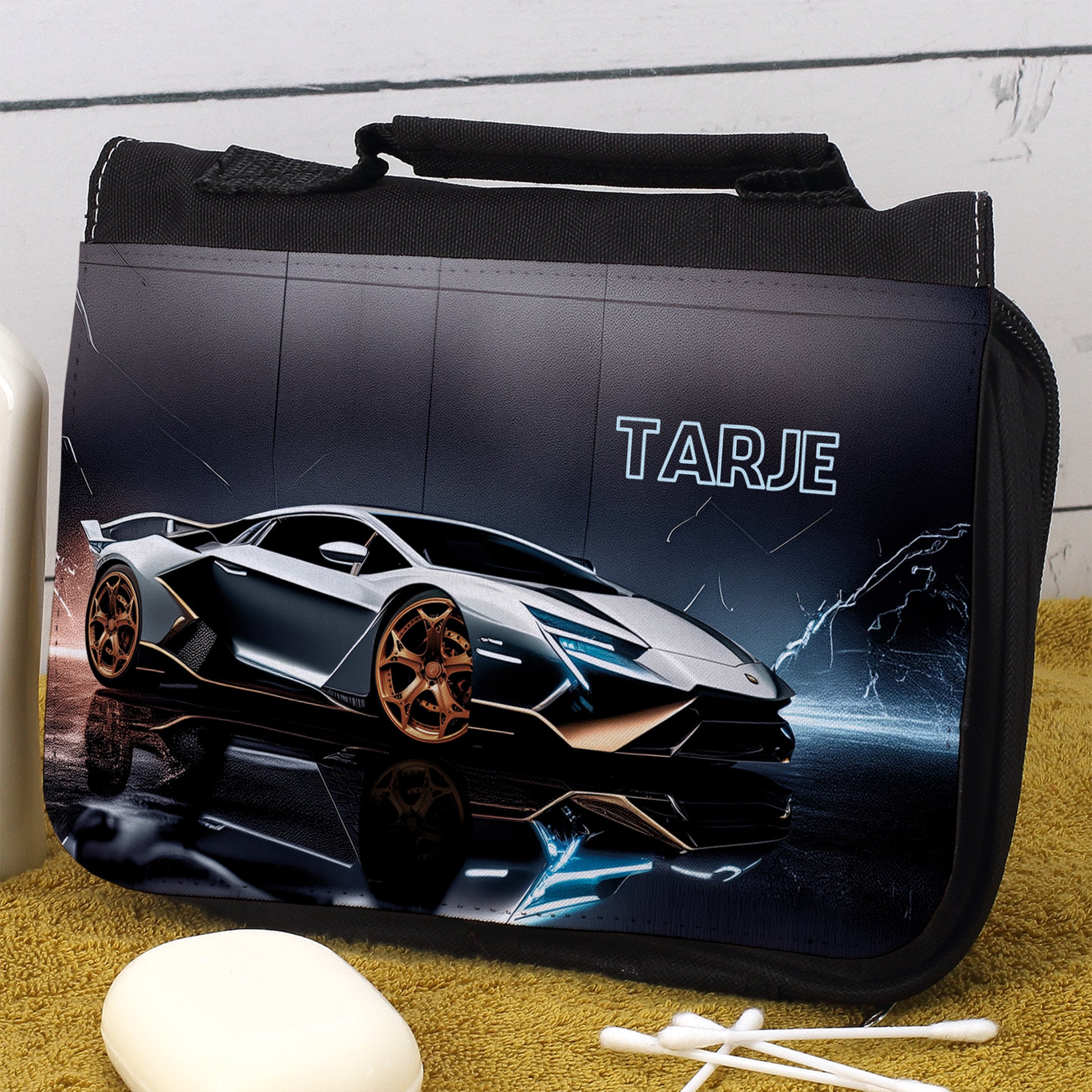Personalisierte Waschtasche mit Rennwagen und Name Tarje, liegend auf gelbem Handtuch