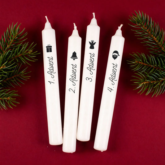 Vier weiße Adventskerzen im 4er-Set mit Weihnachtsmotiven Geschenk, Glocke, Engel und Weihnachtsmann sowie Beschriftung 1. bis 4. Advent