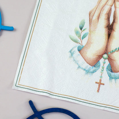 Detailaufnahme der Serviette mit feinem Rahmen und christlichem Motiv aus Händen, Rosenkranz und Kreuz