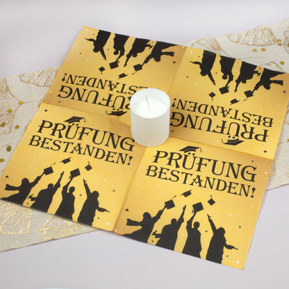 Aufgefaltete Serviette Prüfung bestanden als Tischdeko mit Kerze – perfekt für Schulabschluss oder Studium