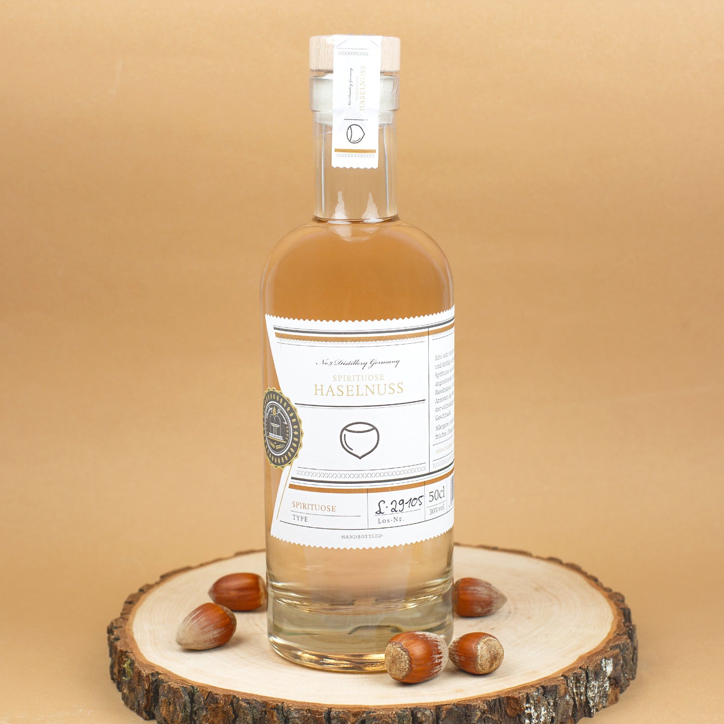 Flasche Haselnussschnaps dekoriert auf Baumscheibe mit Haselnüssen