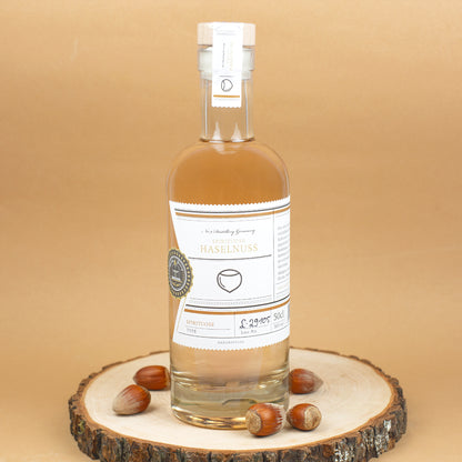 Flasche Haselnussschnaps dekoriert auf Baumscheibe mit Haselnüssen